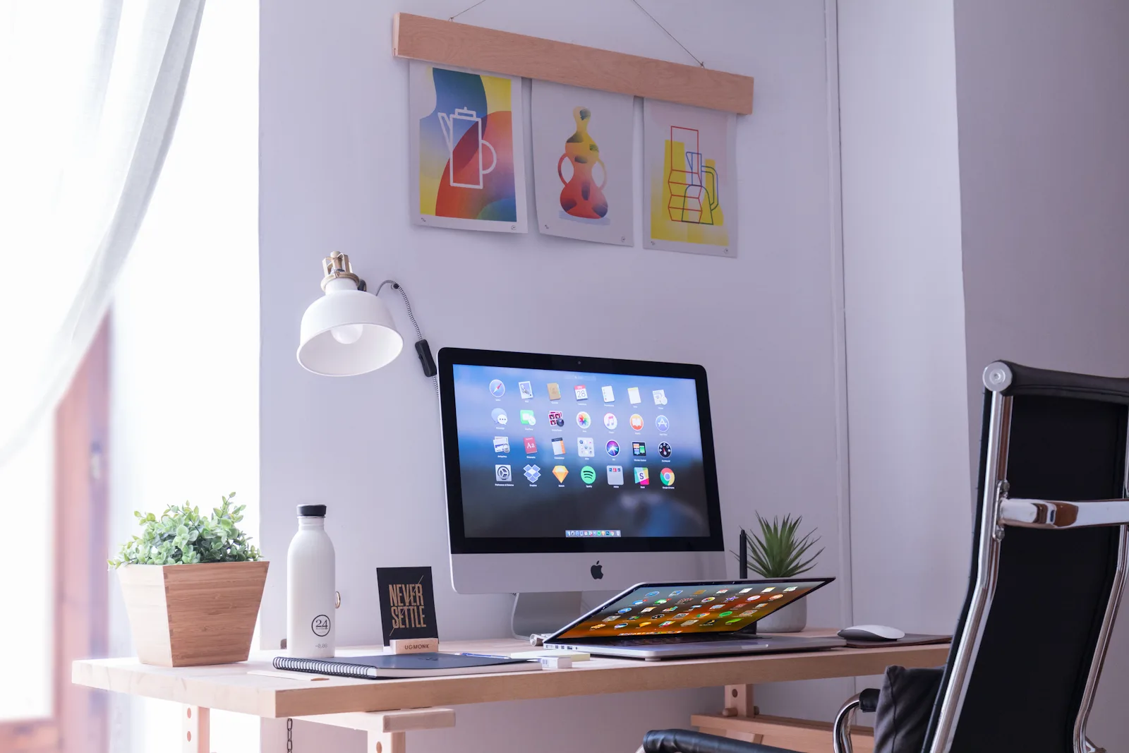 窓から光が差し込む、PCと植物を置いたデスク